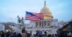 An image of a man with a flag during a riot at the US Capitol.